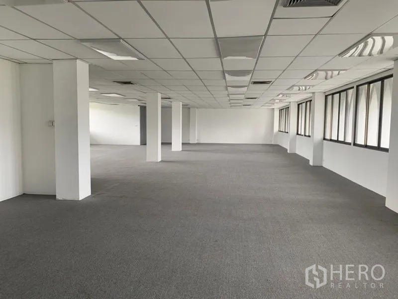 สำนักงาน ให้เช่าในRatchathewi, Bangkok - พื้นที่สำนักงานทรงสี่เหลี่ยมยาว มีเสาหลายต้น ปูพรม และหน้าต่างเรียงตัวรับแสงธรรมชาติ