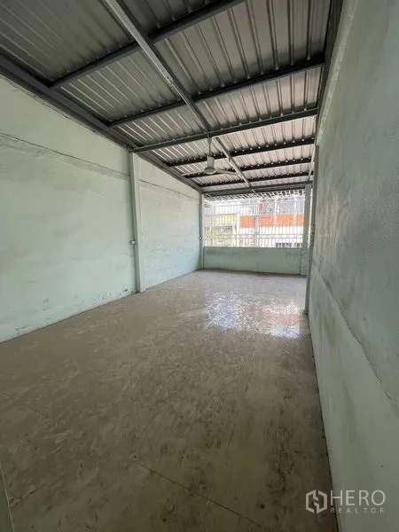 Shophouse for sale in Sathon, Bangkok - Covered rear terrace or storage zone with metal roof and window grilles.