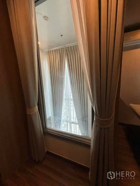 คอนโด ให้เช่าหรือขายในWatthana, Bangkok - หน้าต่างภายในพร้อมผ้าม่าน มองลงสู่ห้องนั่งเล่นเพดานสูงและผ้าม่านทิ้งตัว