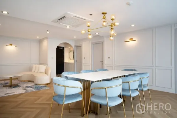 คอนโด ขายในBang Na, Bangkok - พื้นที่นั่งเล่น-ทานอาหารแบบเปิดโล่ง มีโคมไฟโมเดิร์น ซุ้มโค้งสู่ครัว และผนังบัวคลาสสิก
