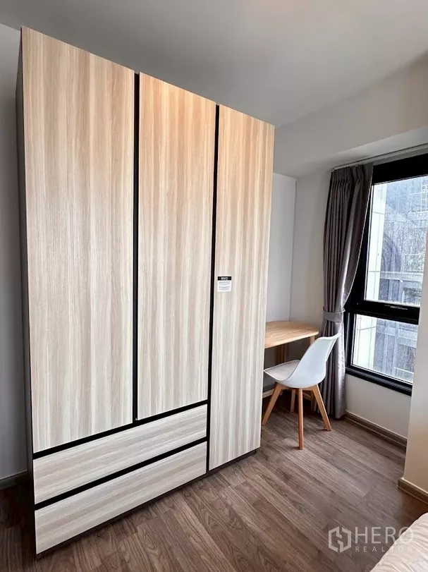 Condominium for rent in Chatuchak, Bangkok - Wardrobe and corner work desk beside bright window in bedroom.