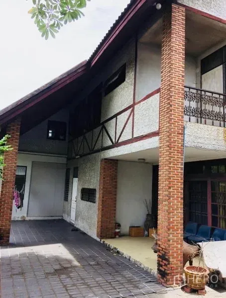 บ้าน ขายในPhra Khanong, Bangkok - ที่จอดรถในร่ม เสาอิฐแดง ระเบียง และหลังคาลาดของบ้านเดี่ยว