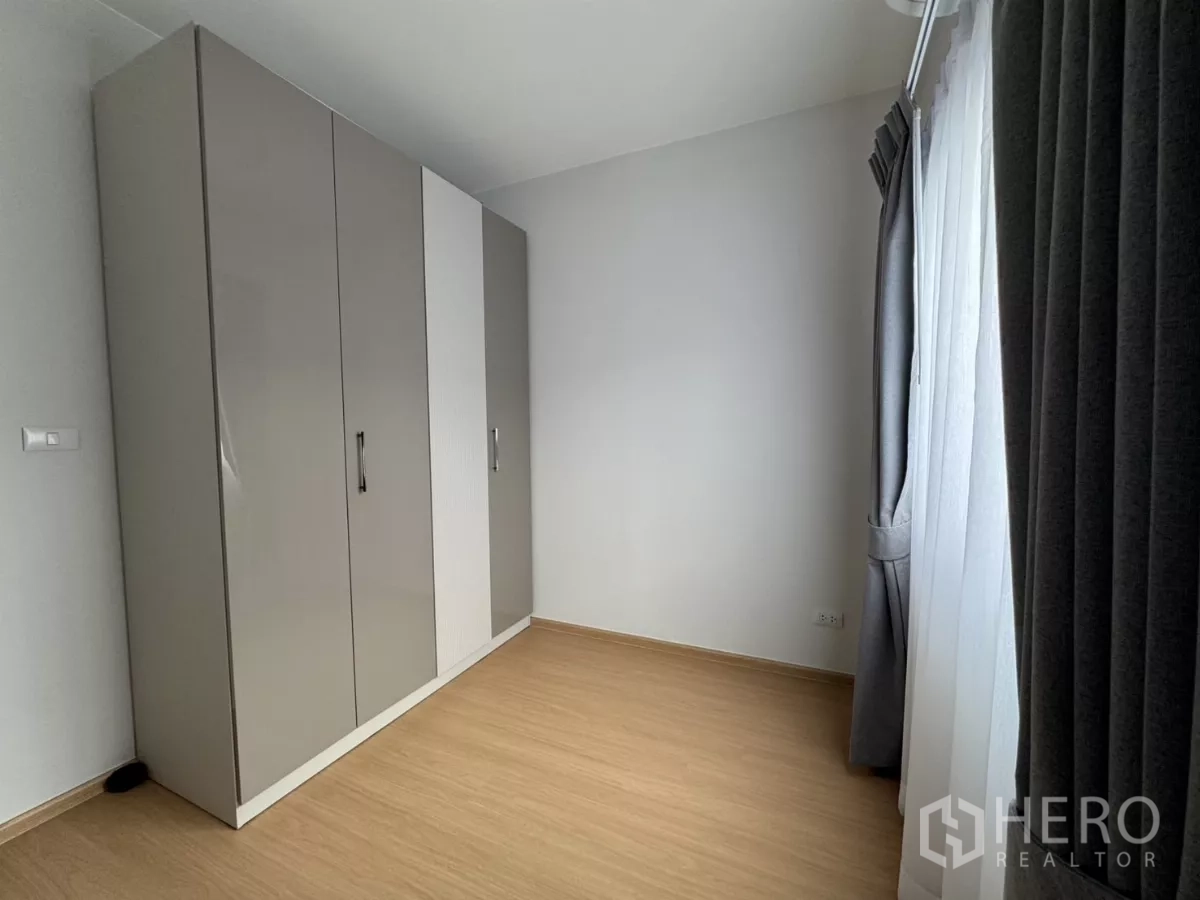 Townhouse for rent in Bang Phli, Samut Prakan - Third bedroom or multipurpose room with a large wardrobe and window.