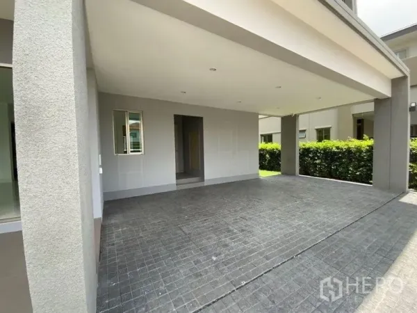 联排别墅 出租在Prawet, Bangkok - 带顶双车位车棚与铺砖车道入口。