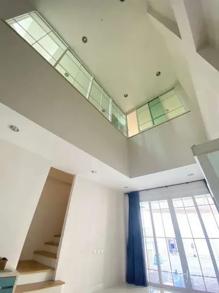 带办公室的家 出租或出售 - 中庭视角可见夹层与大面积室内窗户，旁为楼梯。