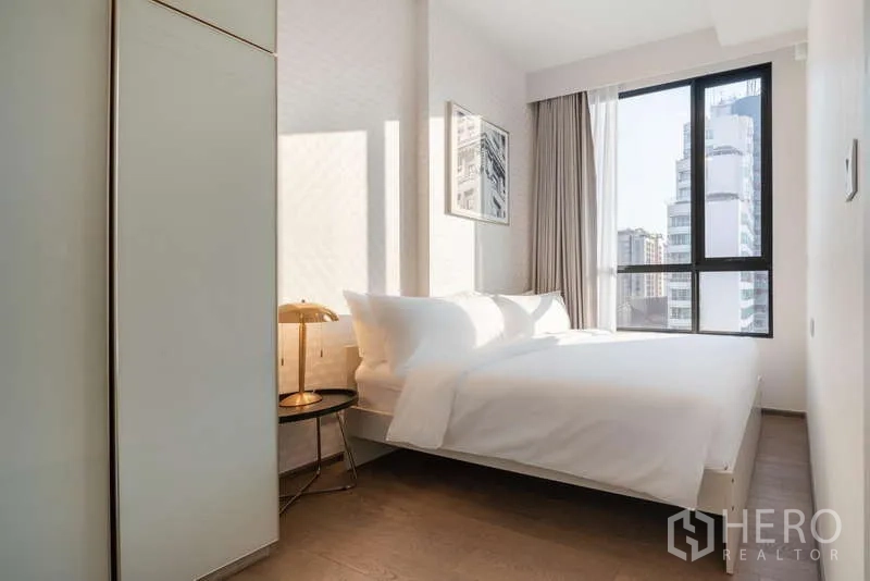 Condominium for rent - Sunlit bedroom with large window, double bed and city view.