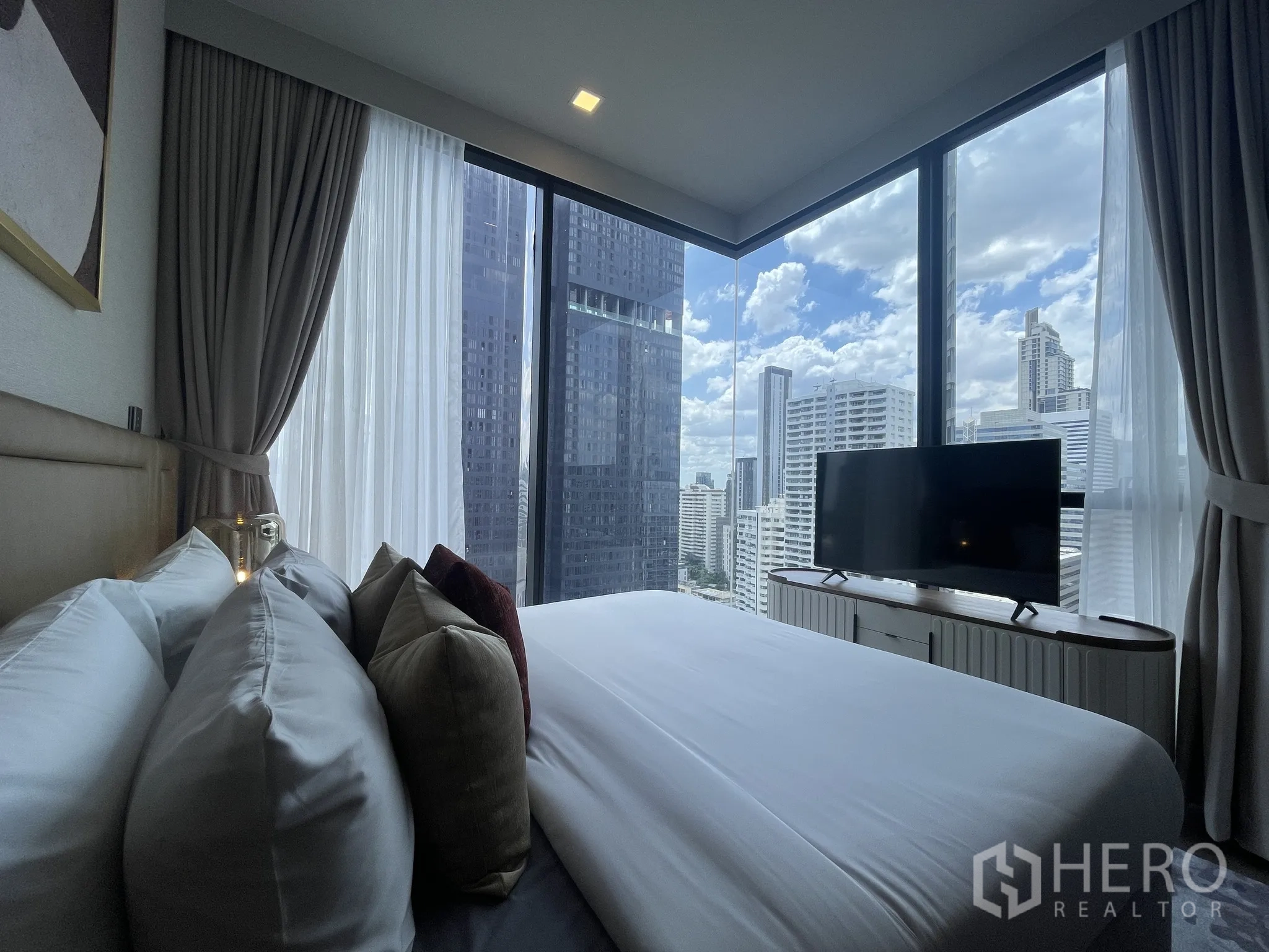 Condominium for rent in Watthana, Bangkok - Corner bedroom with floor-to-ceiling windows and panoramic city skyline.