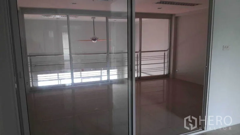 Office Space for rent in Bueng Kum, Bangkok - Glass-partitioned meeting room with mezzanine railing and polished tiled floors.