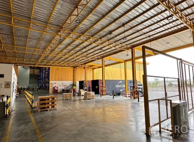 Warehouse for rent in Lat Krabang, Bangkok - Covered loading area with raised dock platform, pallets, and container access for efficient goods handling.