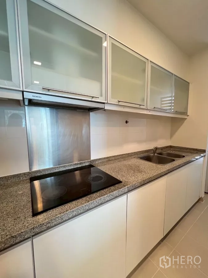 公寓 出租在Khlong Toei, Bangkok - 厨房细节：陶瓷灶台、双水槽与不锈钢挡板，花岗岩操作台。