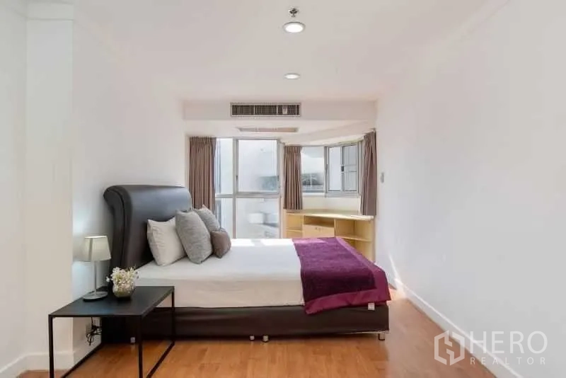 公寓 出租在Khlong Toei, Bangkok - 主卧带飘窗、筒灯与床头柜，木地板温馨舒适。