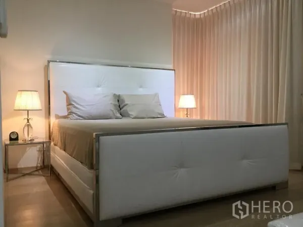 คอนโด ให้เช่าหรือขายในWatthana, Bangkok - ห้องนอนหลักอบอุ่น เตียงบุหนังสีขาวและโคมไฟหัวเตียง