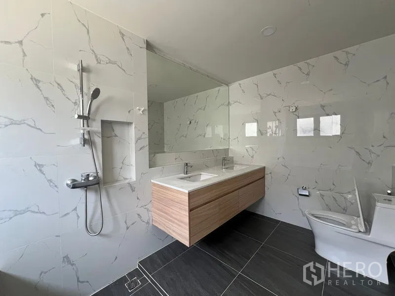 Detached House for rent in Bang Phli, Samut Prakan - Modern bathroom with double vanity, walk-in shower and marble tiles.