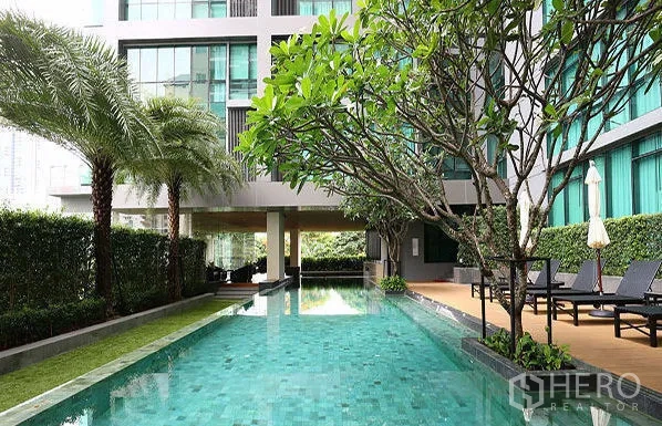 Condominium for rent or sale in Watthana, Bangkok - Condo facilities include a landscaped lap pool with sun deck and greenery.