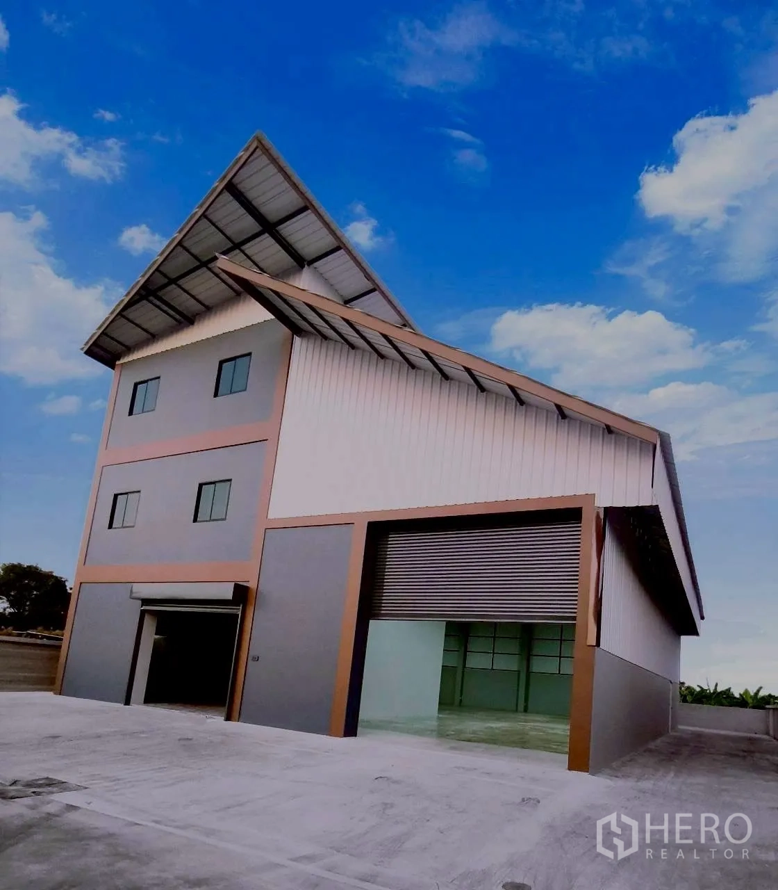 仓库 for rent in Mueang Nonthaburi, Nonthaburi - 仓库外观，斜屋顶、大型卷帘门与混凝土场地。