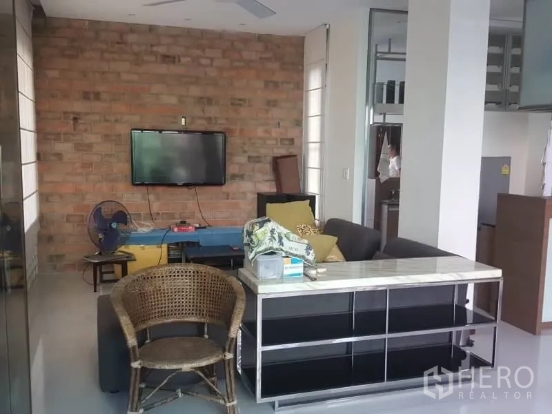 สำนักงานที่บ้าน ให้เช่าหรือขายในBang Rak, Bangkok - ห้องรับรองผนังอิฐโชว์แนว ติดทีวี และชุดที่นั่งสบาย ๆ