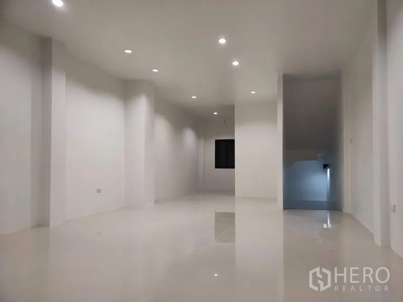 Home Office for sale in Lam Luk Ka, Pathum Thani - Upper-floor open area with staircase nook and minimalist white finishes.
