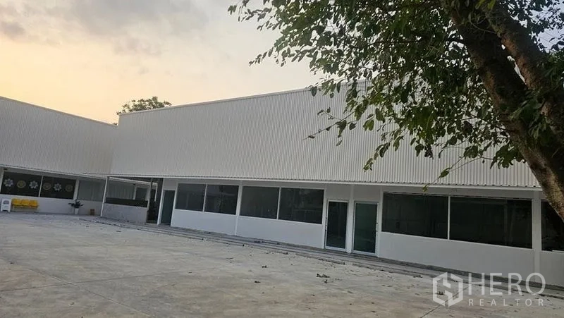 สำนักงาน ให้เช่าในBang Phli, Samut Prakan - มุมมองด้านหน้าอาคารสำนักงานทรงตัวแอล กระจกบานใหญ่หันสู่ลานปูพื้นเปิดโล่ง