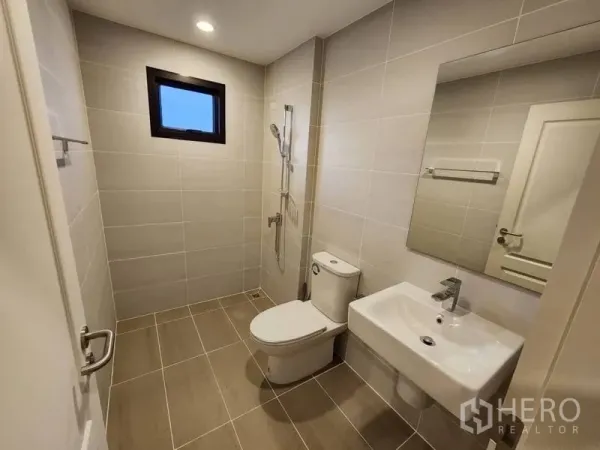 Detached House for rent in Prawet, Bangkok - Modern bathroom with walk-in shower, toilet and basin, finished in beige tiles.