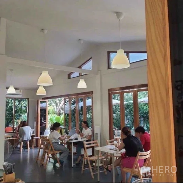 พื้นที่ขายปลีก ให้เช่าในSuan Luang, Bangkok - พื้นที่นั่งรับประทานภายในสว่าง โปร่ง โคมแขวน หน้าต่างกรอบไม้ และโต๊ะเก้าอี้เรียบง่าย