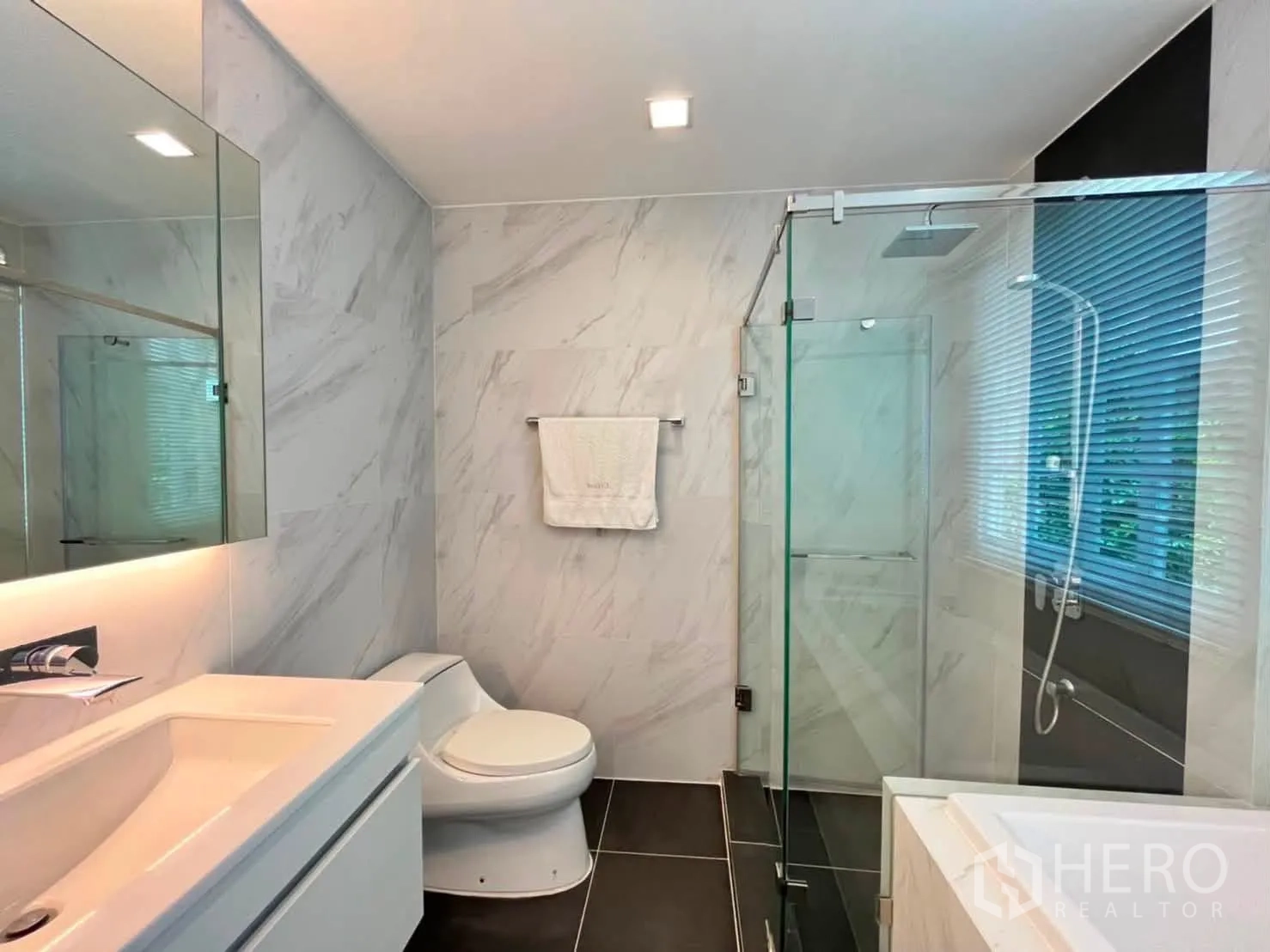 Townhouse for rent in Lat Phrao, Bangkok - Modern bathroom with glass shower enclosure and large vanity.