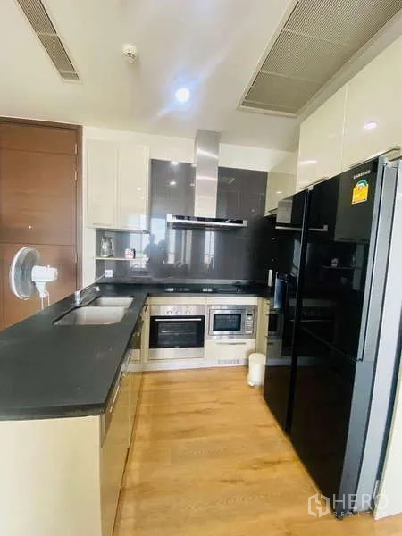 公寓 出售在Watthana, Bangkok - L 型厨房，内置烤箱、微波炉与双门冰箱。
