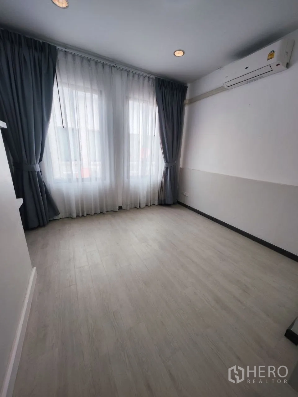 家庭办公室 for rent in Bang Na, Bangkok - 空房间配大窗、窗帘、空调与木地板。