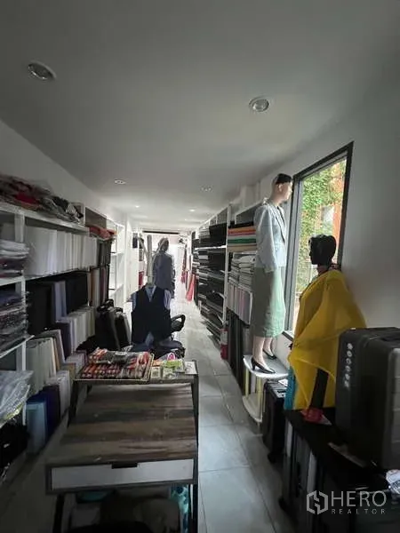 零售空间 出租在Khlong Toei, Bangkok - 长条形展示区，墙面货架、大侧窗与瓷砖地面。