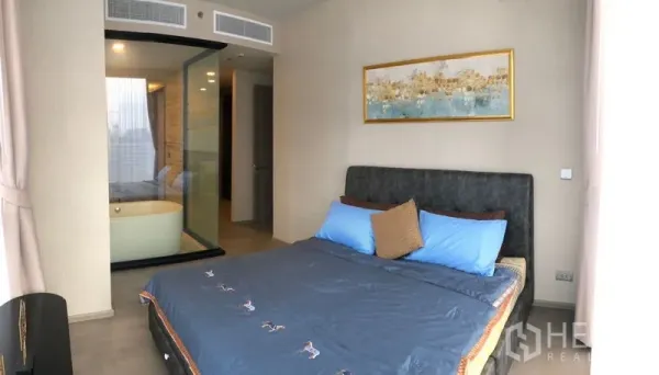Condominium for rent in Watthana, Bangkok - Master bedroom looking toward a glass-partitioned ensuite with soaking bathtub.