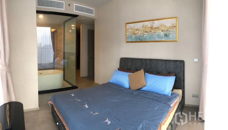 Condominium for rent in Watthana, Bangkok - Master bedroom looking toward a glass-partitioned ensuite with soaking bathtub.
