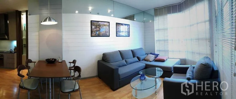 คอนโด ให้เช่าในKhlong Toei, Bangkok - ห้องนั่งเล่นสว่าง โซฟาเข้ามุม โต๊ะกลางกระจก และหน้าต่างบานใหญ่พร้อมมู่ลี่