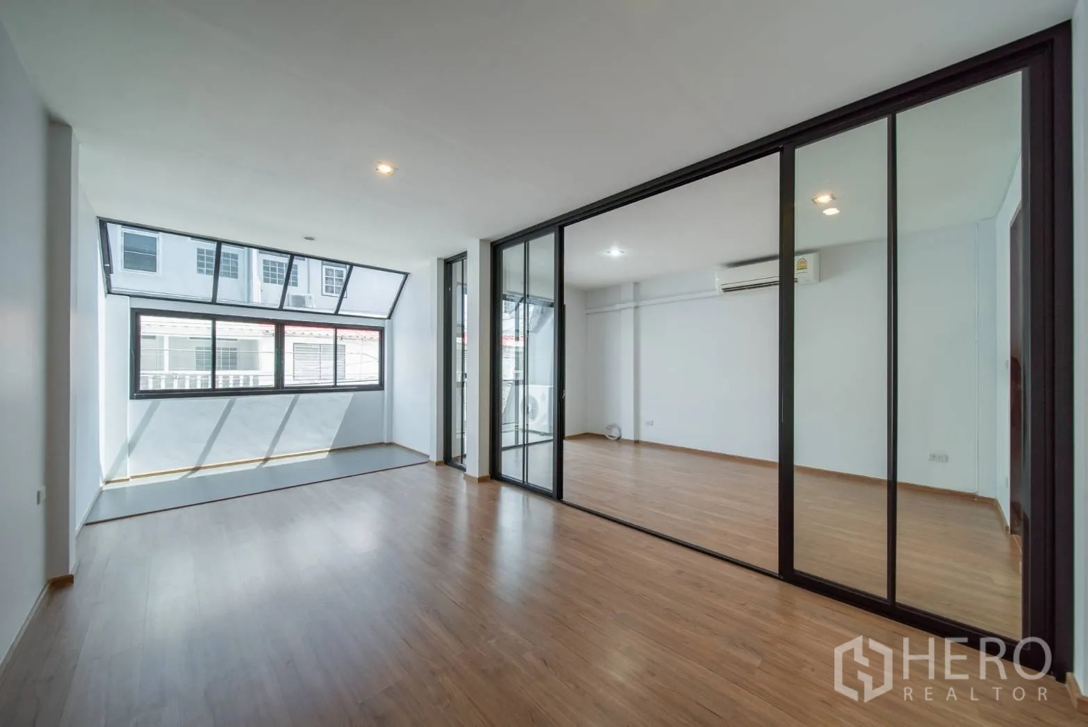 ทาวน์เฮาส์ ให้เช่าในWatthana, Bangkok - ห้องโล่งพื้นไม้ กั้นห้องด้วยผนังกระจกและหน้าต่างบานกว้าง