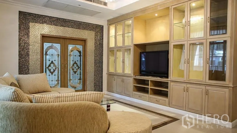 Detached House for rent in Bang Phli, Samut Prakan - Cozy living room featuring built-in wall cabinets, TV and decorative double doors.