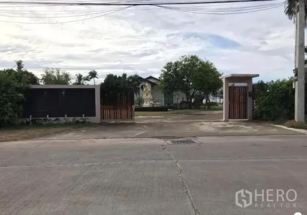 货栈 出售在Chon Buri - 临街主入口与门岗，大门外可见电线。