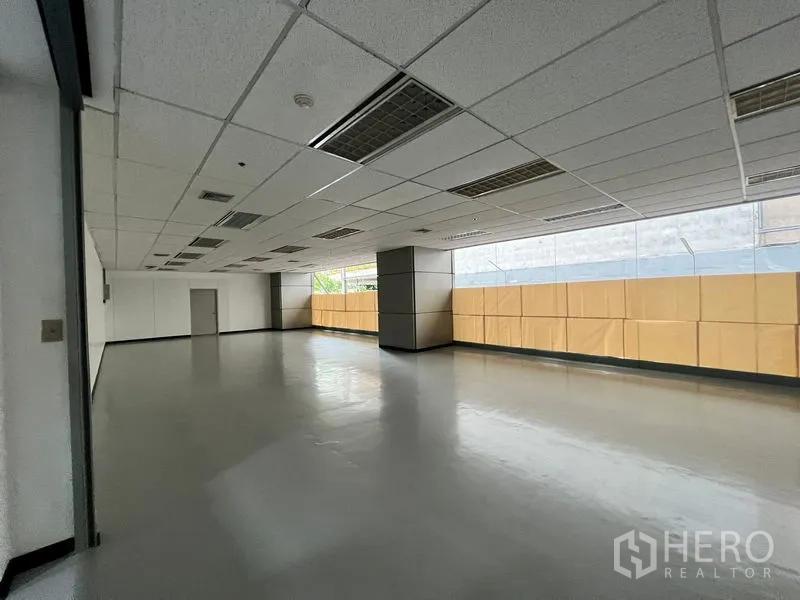 พื้นที่ขายปลีก ให้เช่า - พื้นที่ร้านค้ากว้างขวาง พื้นมันเงา เพดานกริดพร้อมไฟ และหน้าต่างยาวรับแสงธรรมชาติ