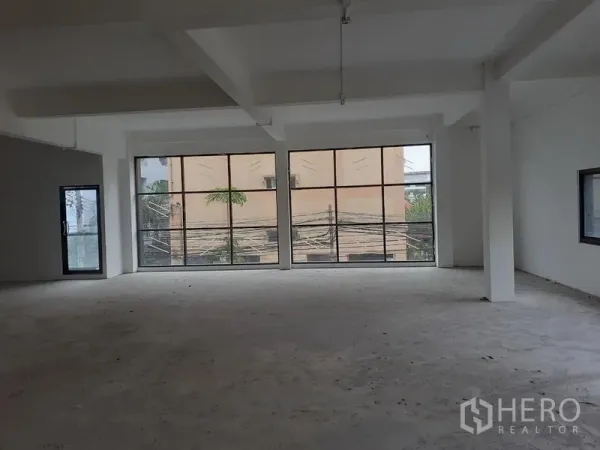 Office Space for rent in Khlong Toei, Bangkok - Bright shell office interior featuring floor-to-ceiling black-framed windows and a side glass entry door.