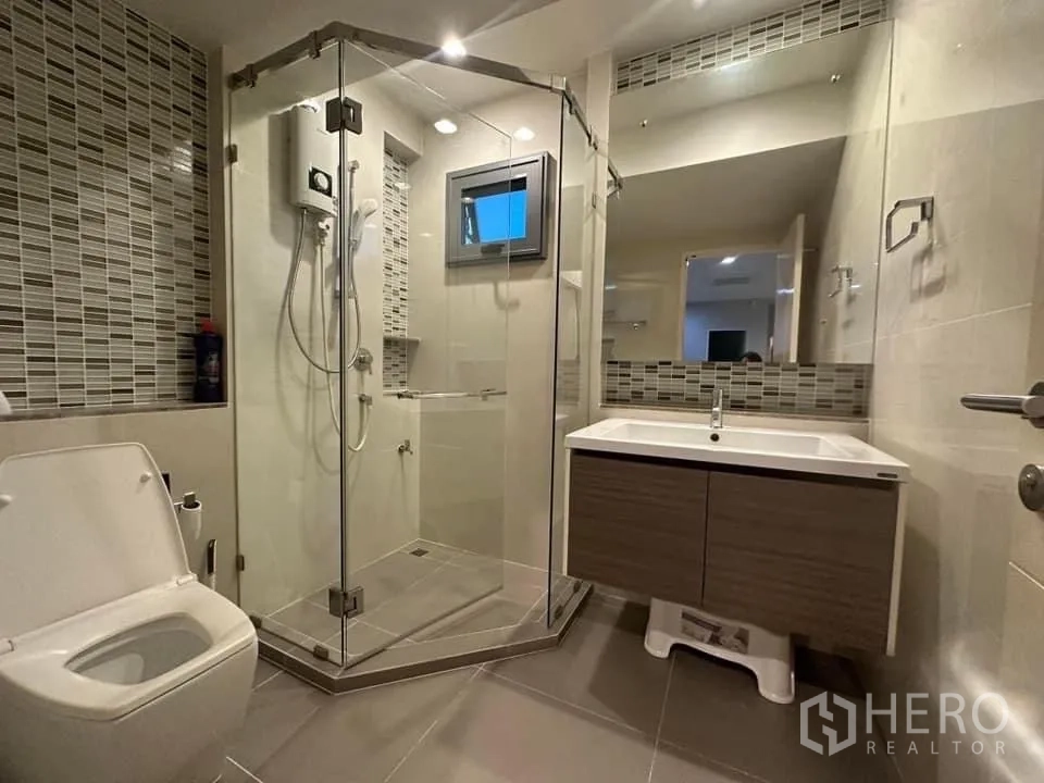 Detached House for rent in Bang Kapi, Bangkok - Contemporary bathroom with glass shower enclosure, floating vanity and mosaic accents.