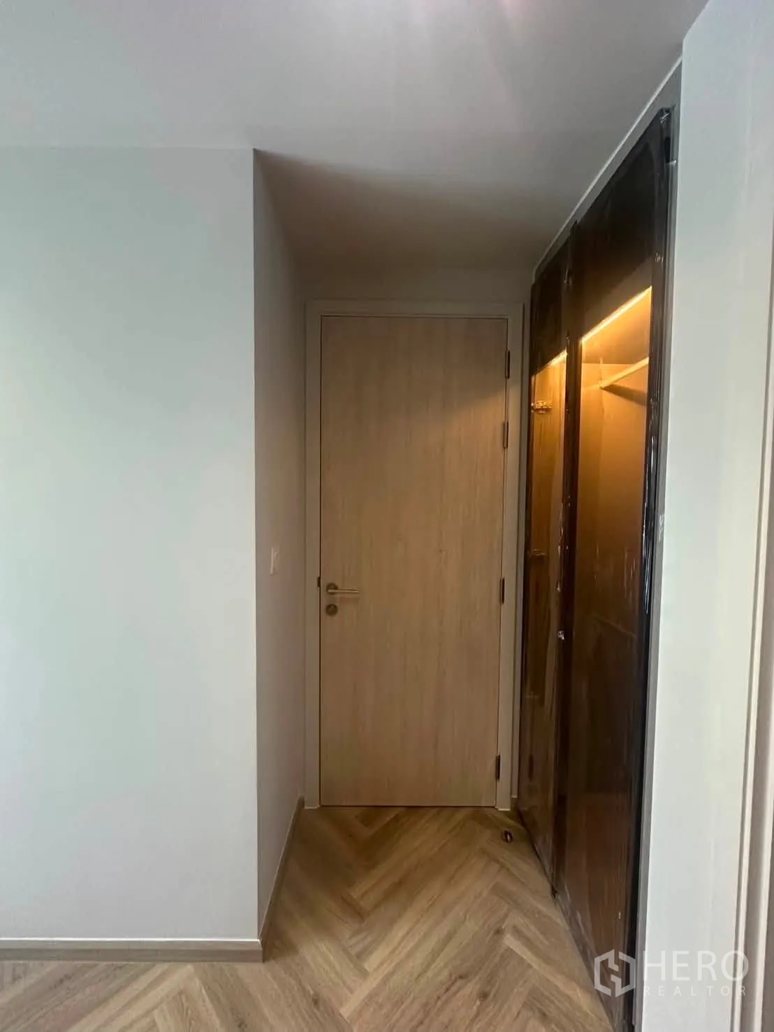 คอนโด for rent in Watthana, Bangkok - โถงทางเข้าปูพื้นลายก้างปลา ประตูไม้ และตู้บิลท์อิน