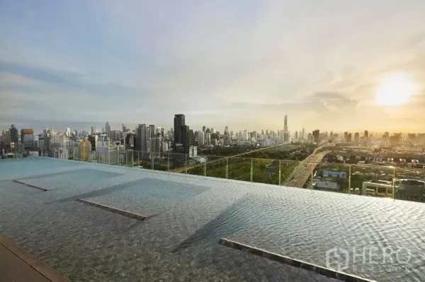 公寓 出售在Ratchathewi, Bangkok - 屋顶无边泳池，日落下的曼谷天际线全景。