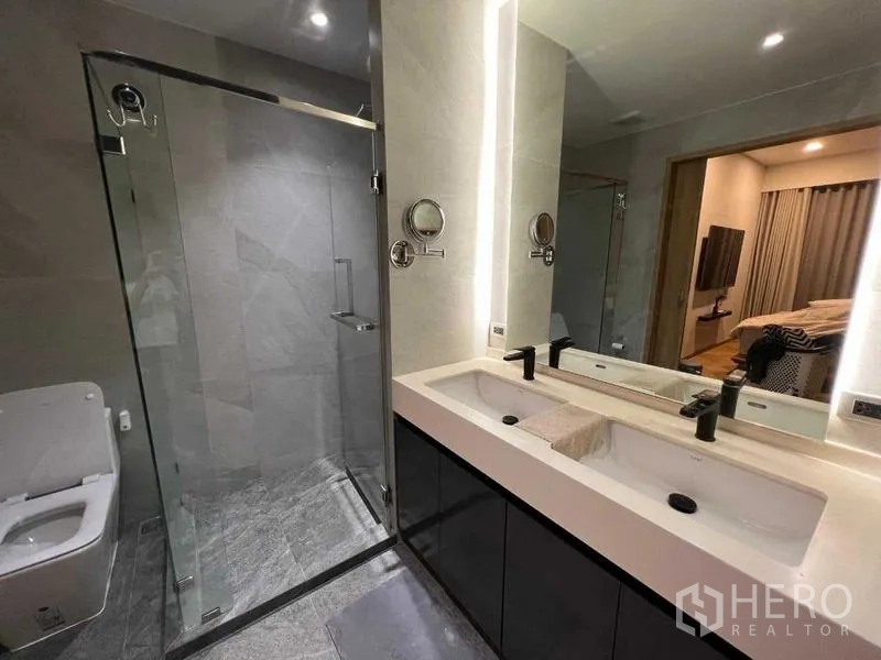 公寓 出租或出售在Phaya Thai, Bangkok - 宽敞浴室，带双洗手台、背光镜与玻璃步入式淋浴间。