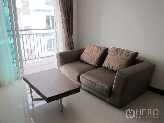 คอนโด ให้เช่าในKhlong Toei, Bangkok - โซฟาสองที่นั่งกับโต๊ะกลางข้างประตูบานเลื่อนออกระเบียงมองเห็นวิวเมือง