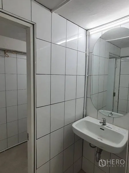 อาคารพาณิชย์ ให้เช่าในPhra Khanong, Bangkok - ห้องน้ำกระเบื้องสีขาวพร้อมอ่างล้างหน้าแขวนผนังและกระจกทรงกลม