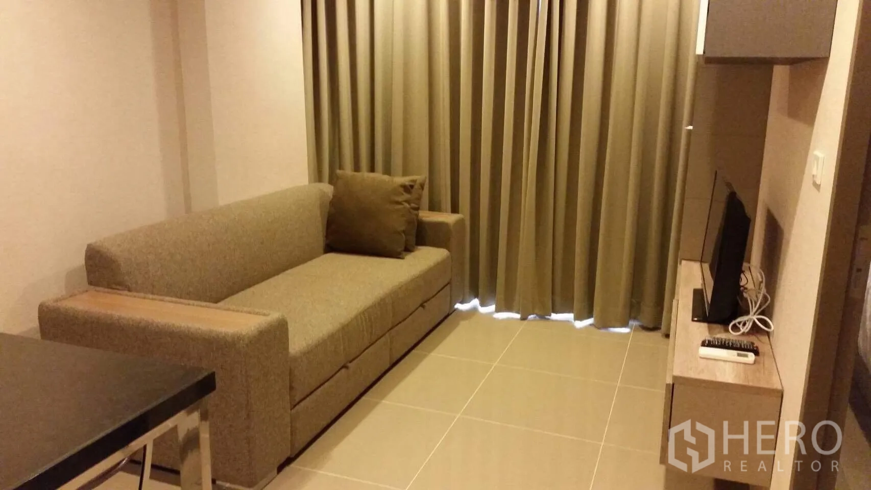 คอนโด ให้เช่าในWatthana, Bangkok - ห้องนั่งเล่นมีโซฟาผ้า ผ้าม่านทึบสูงจรดเพดาน พื้นกระเบื้อง และชั้นวางทีวีลอย