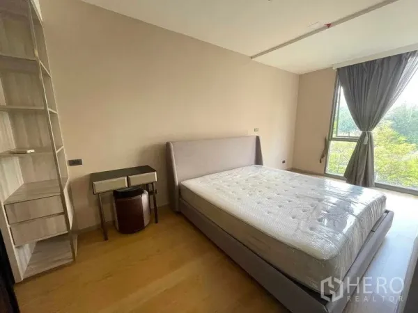 公寓 出租或出售在Watthana, Bangkok - 明亮卧室，软包床、内置搁架与大窗，眺望绿树景观。