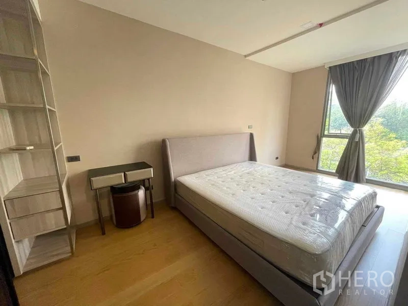 公寓 出租或出售在Watthana, Bangkok - 明亮卧室，软包床、内置搁架与大窗，眺望绿树景观。