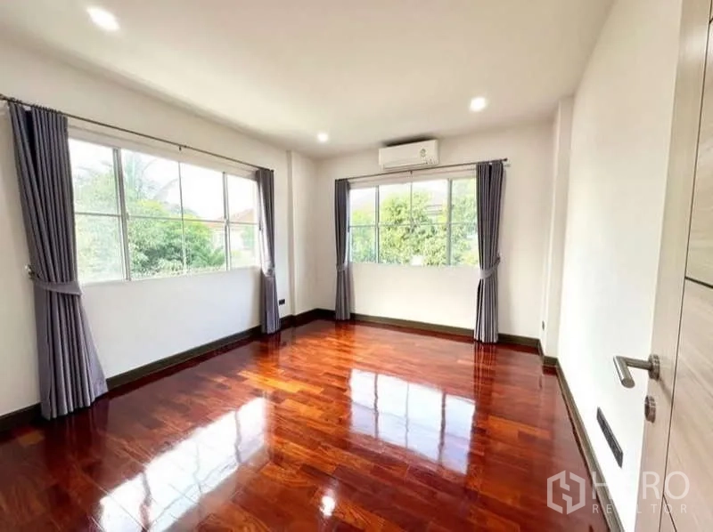 Detached House for rent in Phasi Charoen, Bangkok - Bright bedroom with large windows, curtains and hardwood flooring.