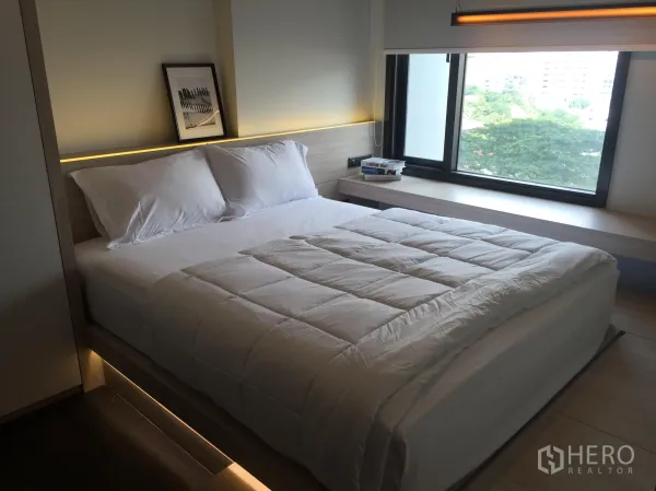 公寓 出租在Watthana, Bangkok - 采光良好的卧室，木质平台床与大窗户，绿景视野。