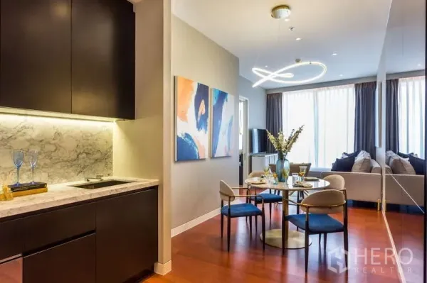 คอนโด ให้เช่าในWatthana, Bangkok - มุมครัวขนาดกะทัดรัดพื้นผิวหินอ่อน เปิดสู่โซนทานอาหารและนั่งเล่น โต๊ะกลม ไฟเพดานแบบวงแหวน และผ้าม่านบานสูง