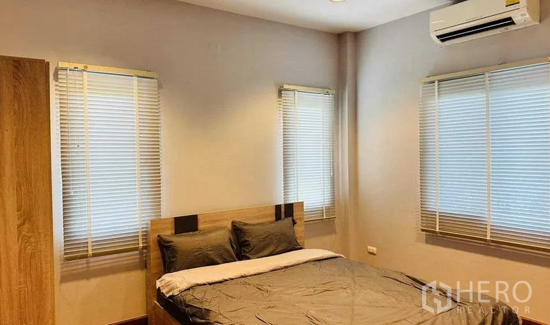 บ้าน ให้เช่าในLam Luk Ka, Pathum Thani - ห้องนอนแขก เตียงไม้ หน้าต่างสามด้าน พร้อมเครื่องปรับอากาศ