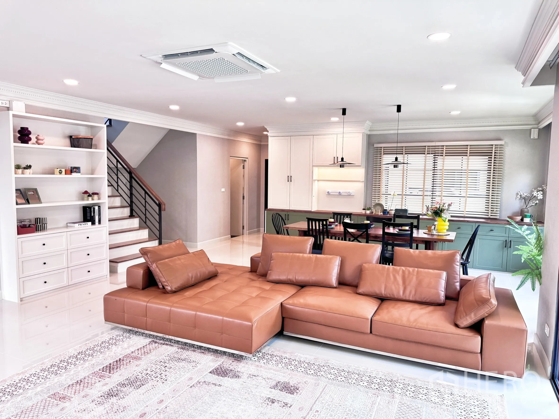 Detached House for rent in Bang Phli, Samut Prakan - Living area with sofa, built-in shelving, staircase, and cabinetry with pendant lights.